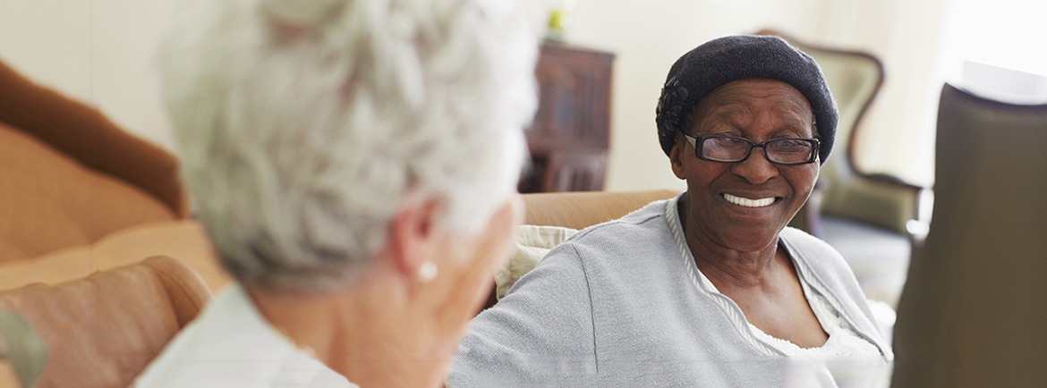 Two elderly women sitting together and chatting in the retirement home